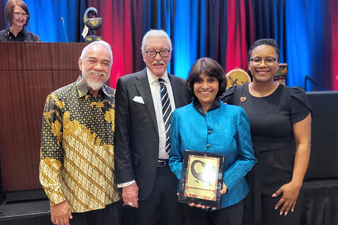 Dilys Schoorman with NAME award flanked by Lakia Scott (President-Elect, NAME), G. Prtichy Smith (NAME Founder and Award Donor), and Ludy van Broekhuizen.  