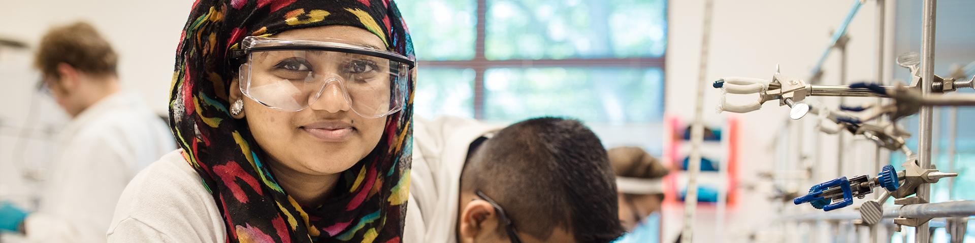 Student in a biology lab smiling at the camera