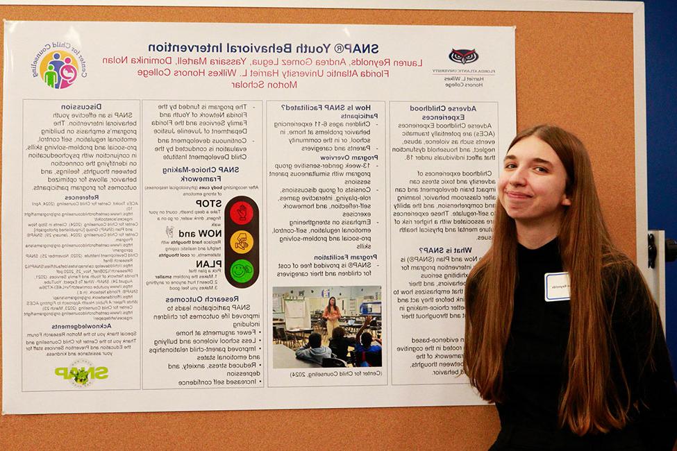 Lauren Reynolds standing in front of her research poster.