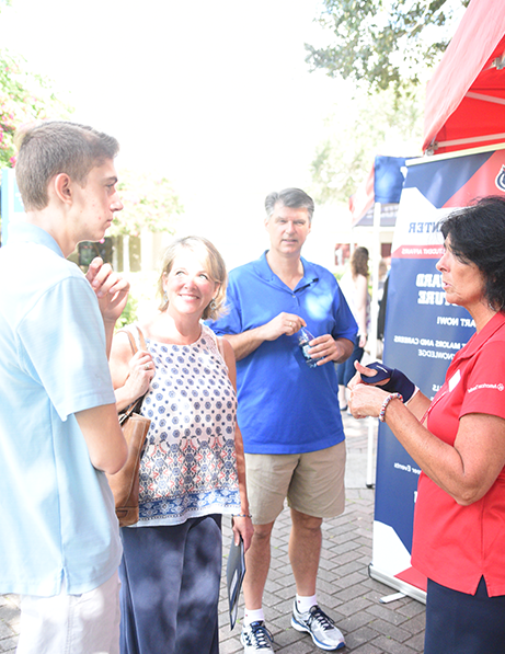 Student speaking with FAU employee at an event